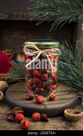 Rosehip dans un pot-cadeau sur fond de bois. Banque D'Images