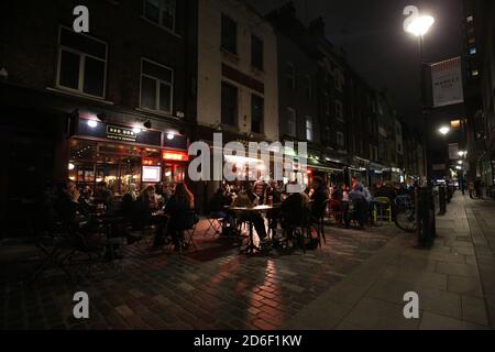 Les personnes qui ont un verre devant le chien rouge à Berwick Street, Londres, la dernière nuit avant que la ville soit mise dans les restrictions de niveau 2 pour freiner la propagation du coronavirus. Banque D'Images