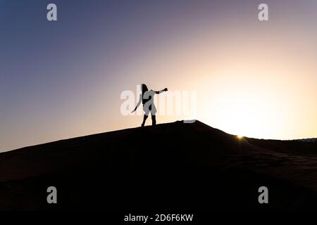 Personne sur une dune devant le coucher du soleil sur les dunes de Maspalomas, Gran Canaria, Espagne Banque D'Images