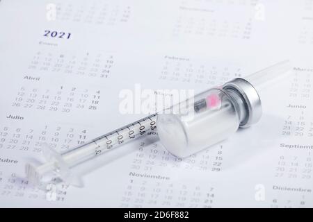 Concept médical. Dans le calendrier, seringue avec contenant de vaccin épidémique. Banque D'Images