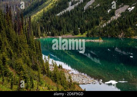 Lac vert dans les montagnes boisées Banque D'Images