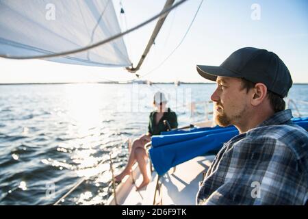 Jeune homme qui profite de la voile d'été pendant l'heure d'or Banque D'Images