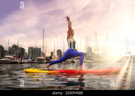 Une femme aventureuse sur un paddle-board pratique le yoga Banque D'Images