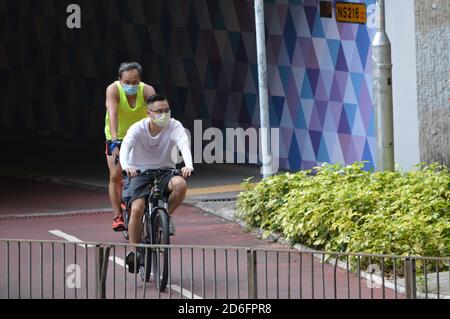 Des hommes qui font du vélo sur une piste cyclable séparée de la classe à Yuen long, Hong Kong Banque D'Images