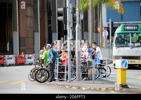 De nombreux cyclistes se sont empaquetés sur une île de refuge piétonnier à une traversée en quinconce à Yuen long, Hong Kong Banque D'Images