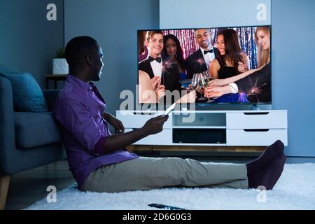 Grande version de l'homme africain regardant la télévision film ou la télévision Banque D'Images