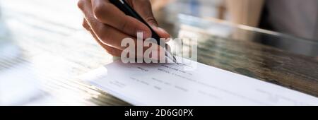 African Writing Money Check. Signer un chèque de paie Banque D'Images