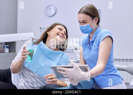 Dentisterie, traitement dentaire, femme médecin dentiste consulte le patient sous la chaise Banque D'Images