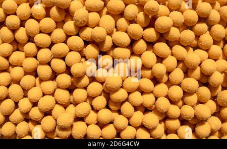 Fond d'arachides salées enrobées de fromage. Grains d'arachide frits avec un revêtement d'épices salées. Vue de dessus. Arachides grillées dans une sauce au fromage Banque D'Images