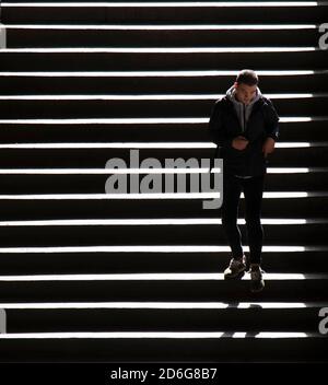 Belgrade, Serbie - 09 octobre 2020 : jeune homme marchant dans les escaliers publics de la ville, en contraste élevé Banque D'Images