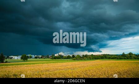 Allemagne, Stuttgart, ciel sombre spectaculaire d'un front d'orage violent et orage au-dessus du village et des champs en été Banque D'Images