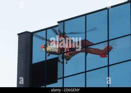 Birmingham, Royaume-Uni, le 17 octobre 2020. Samedi matin, vue inhabituelle dans le centre-ville de Birmingham, Super Puma Helicopter a conduit des ascenseurs de charge entre les blocs de bureaux en hauteur de Snow Hill Queensway. HeliRig a organisé les opérations en utilisant un aéroport suisse AS3332C Super Puma basé à l'aéroport Wolverhampton Halfpenny Green pour la durée de l'opération, qui comprenait la facilitation d'un décollage vertical à l'aide d'un câble de levage de 80 M. Le Super Puma reélu est la fenêtre des bureaux adjacents. Crédit : Paul Bunch/Alamy Live News. Banque D'Images