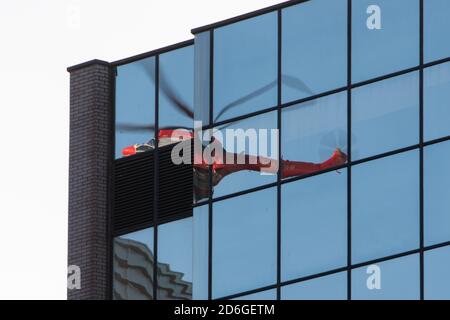 Birmingham, Royaume-Uni, le 17 octobre 2020. Samedi matin, vue inhabituelle dans le centre-ville de Birmingham, Super Puma Helicopter a conduit des ascenseurs de charge entre les blocs de bureaux en hauteur de Snow Hill Queensway. HeliRig a organisé les opérations en utilisant un aéroport suisse AS3332C Super Puma basé à l'aéroport Wolverhampton Halfpenny Green pour la durée de l'opération, qui comprenait la facilitation d'un décollage vertical à l'aide d'un câble de levage de 80 M. Le Super Puma reélu est la fenêtre des bureaux adjacents. Crédit : Paul Bunch/Alamy Live News. Banque D'Images