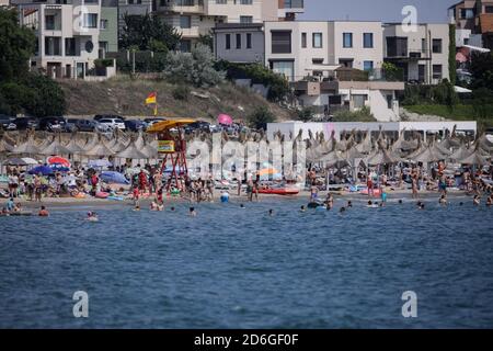 Constanta, Roumanie - 5 juillet 2020: Les gens apprécient l'eau et le sable sur une plage de la mer Noire pendant l'épidémie de Covid-19 pendant la journée ensoleillée d'été. Banque D'Images