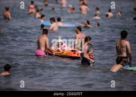 Constanta, Roumanie - 5 juillet 2020: Les gens apprécient l'eau et le sable sur une plage de la mer Noire pendant l'épidémie de Covid-19 pendant la journée ensoleillée d'été. Banque D'Images