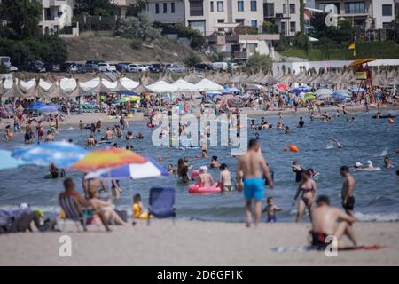 Constanta, Roumanie - 5 juillet 2020: Les gens apprécient l'eau et le sable sur une plage de la mer Noire pendant l'épidémie de Covid-19 pendant la journée ensoleillée d'été. Banque D'Images