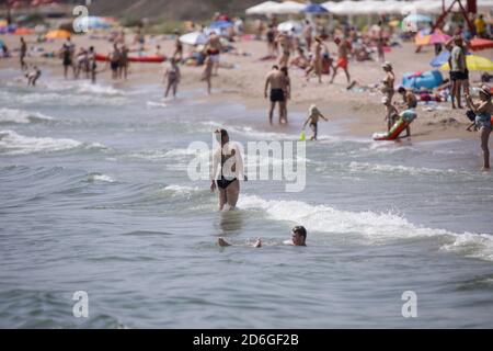 Constanta, Roumanie - 5 juillet 2020: Les gens apprécient l'eau et le sable sur une plage de la mer Noire pendant l'épidémie de Covid-19 pendant la journée ensoleillée d'été. Banque D'Images