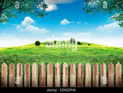 Clôture en bois dans un champ vert et ciel bleu avec des nuages Banque D'Images