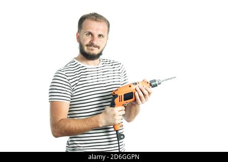 Un homme barbu résolu tient un outil de puissance - perceuse électrique dans ses mains. Isolé sur fond blanc. Banque D'Images