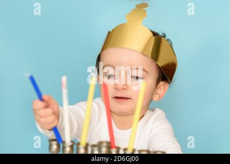 Un petit garçon juif met des bougies sur la menorah traditionnelle. Enfant célébrant Hanukkah Israël vacances. Banque D'Images