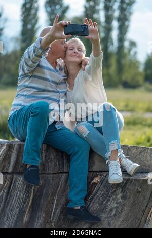 joyeux couple senior datant, prenant le selfie et s'amuser en plein air Banque D'Images