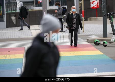 Bruxelles, Belgique. 17 octobre 2020. Des personnes portant des masques de visage marchent dans une rue à Bruxelles, Belgique, 17 octobre 2020. Le Premier ministre belge Alexander de Croo a annoncé vendredi des mesures plus strictes, y compris un couvre-feu national, pour limiter la propagation de la COVID-19 à la fin d'une réunion du Comité de consultation. Selon de Croo, un couvre-feu de minuit à 5 heures sera imposé dans tout le pays à partir de lundi. Credit: Zhang Cheng/Xinhua/Alay Live News Banque D'Images