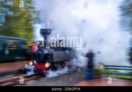 Klutz, plaque de lac mecklembourgeoise, Allemagne. 17 octobre 2020. Sous la pluie et avec beaucoup de vapeur, la locomotive de brigade de 102 ans traverse la station (coup de feu avec un temps d'exposition plus long). Jusqu'en 19.10.2020, la locomotive tire le train de voyageurs sur la ligne de chemin de fer léger 'Kaffeebrenner'. À la fin de la saison, sur le train touristique avec une jauge de 600 millimètres, une locomotive à vapeur historique parcourra la ligne. Le train se rendra à 20 kilomètres à l'heure sur la route de seulement six kilomètres entre Klütz et Reppenhagen. La ligne de chemin de fer dans le nord-ouest du Mecklembourg a été ouverte le 06.06. Crédit : image dpa Banque D'Images