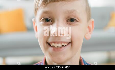 Portrait d'un adorable jeune garçon souriant à l'appareil photo. En arrière-plan flou salle du soleil. Banque D'Images