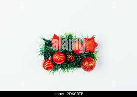 Boîte de rangement pour les jouets traditionnels d'arbre de noël rouge et guirlande verte sur fond blanc, vue du dessus Banque D'Images