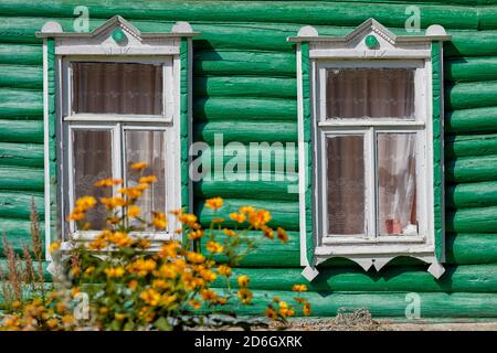 Deux fenêtres dans le mur vert d'une ancienne maison en rondins. Oblast de Kaluga, Russie. Banque D'Images