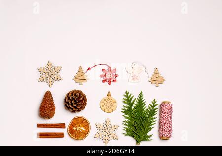 Fond blanc de Noël ou de nouvel an avec branche de genièvre, cannelle, anis, boîte-cadeau, oranges sèches, jouets en bois, bonbons de Noël caramel, cônes de pin Banque D'Images