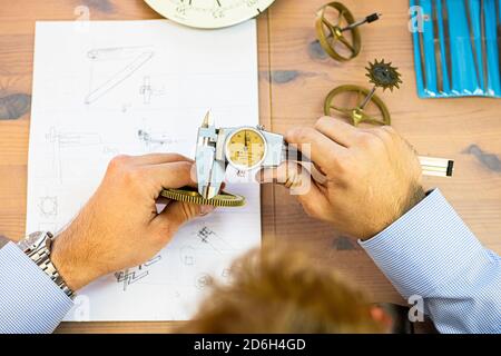 jeune homme assemblant la montre mécanique. production de montre. les mains du mans Banque D'Images