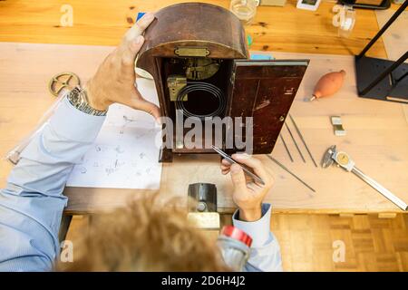 jeune homme assemblant la montre mécanique. production de montre. les mains du mans Banque D'Images