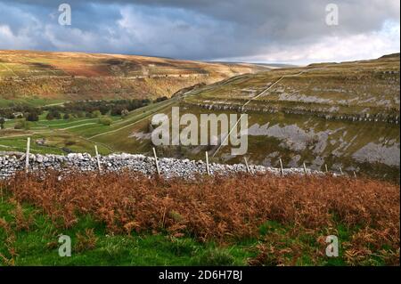 Fin de l'après-midi lumière du soleil d'automne sur la cicatrice de Yew Cogar au-dessus du village d'Arncliffe, Littondale, parc national de Yorkshire Dales, Royaume-Uni. Banque D'Images