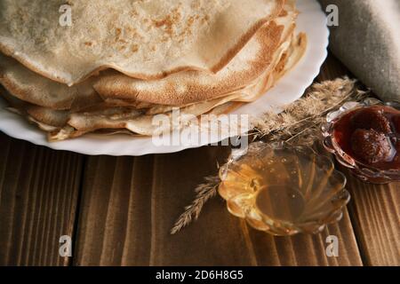 Gros plan crêpes faites maison au miel et aux fraises confiture sur une table en bois Banque D'Images