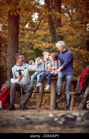 Un couple de personnes âgées et des petits-enfants qui profitent de beaux moments dans le forêt, un beau jour d'automne Banque D'Images