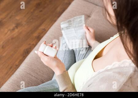 Femme enceinte lecture instructions pour les pilules prescrites, concept de soins de santé, médecine pendant la grossesse. Banque D'Images