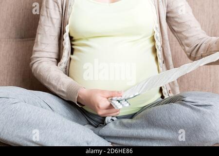 Femme enceinte lecture instructions pour les pilules prescrites, concept de soins de santé, médecine pendant la grossesse. Banque D'Images