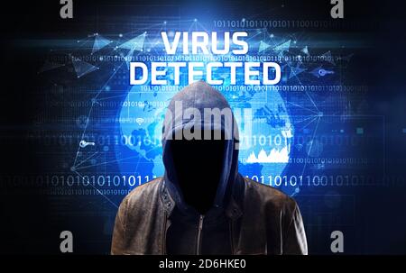 Hacker sans visage au travail avec VIRUS DÉTECTÉ inscription, concept de sécurité informatique Banque D'Images