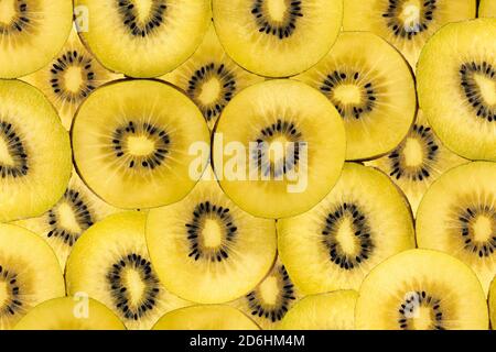Fond fruité composé de nombreuses tranches de kiwis dorés Banque D'Images