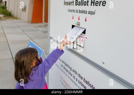 Petite fille plaçant le bulletin dans une boîte de dépôt pour les absents vote Banque D'Images