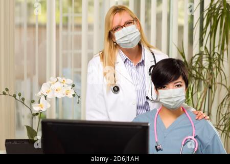 Médecin et infirmière au bureau portant des masques médicaux. Banque D'Images