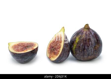 Figues noires fraîches sur fond blanc isolé. Entier et tranché. Banque D'Images