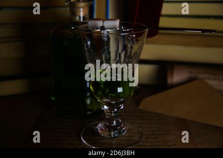 Vue sur un verre et une bouteille isolés en vert sombre ambiance nocturne Banque D'Images