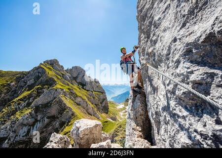 Jeune homme grimpant sur une face rocheuse, via ferrata à la Seekarlspitze, 5-sommet via ferrata, randonnée à la Rofangebirge, Tyrol, Autriche Banque D'Images