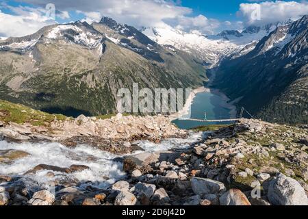 Randonneur, femme sur le pont suspendu à Olpererhuette, réservoir Schlegeis, réservoir Schlegeis, Alpes de Zillertal, glacier Schlegeiskees, Zillertal Banque D'Images