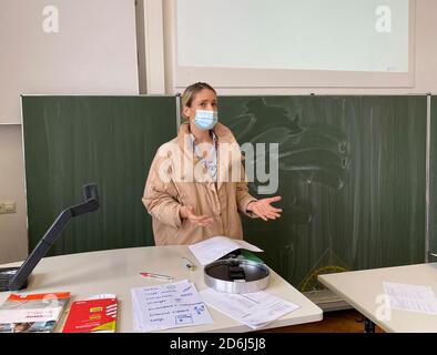 Professeur avec une veste d'hiver épaisse et un masque facial dans l'enseignement en salle de classe, les gestes, la crise corona, Stuttgart, Bade-Wurtemberg, Allemagne Banque D'Images