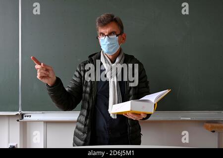 Professeur avec veste d'hiver épaisse, écharpe et masque facial dans l'enseignement en classe, crise Corona, Stuttgart, Bade-Wurtemberg, Allemagne Banque D'Images