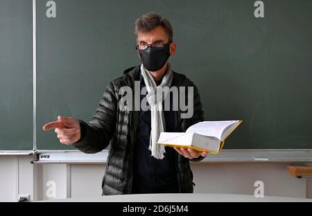 Professeur avec veste d'hiver épaisse, écharpe et masque facial dans l'enseignement en classe, crise Corona, Stuttgart, Bade-Wurtemberg, Allemagne Banque D'Images