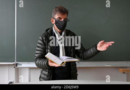 Professeur avec veste d'hiver épaisse, écharpe et masque facial dans l'enseignement en classe, crise Corona, Stuttgart, Bade-Wurtemberg, Allemagne Banque D'Images